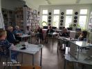 Zdjęcie przedstawia siedzące Panie przy stołach, podczas spotkania Dyskusyjnego Klubu Książek dla dorosłych