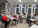 Zdjęcie przedstawia ludzi w bibliotece