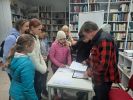 Zdjęcie przedstawia ludzi w Bibliotece.