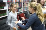 Zdjęcie przedstawia ludzi w Bibliotece.