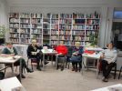 Zdjęcie przedstawia ludzi w bibliotece