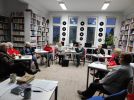 Zdjęcie przedstawia ludzi w bibliotece