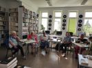 Zdjęcie przedstawia ludzi w bibliotece