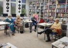Zdjęcie przedstawia ludzi w bibliotece