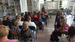 Zdjęcie przedstawia ludzi w bibliotece