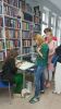 Zdjęcie przedstawia ludzi w bibliotece na spotkaniu autorskim