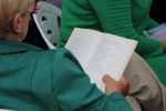 Zdjęcie przedstawia ludzi w na spotkaniu z poezja Wislawy Szymborskiej