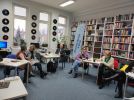 Zdjęcie przedstawia ludzi w bibliotece