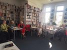 Zdjęcie przedstawia ludzi w bibliotece