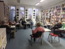 Zdjęcie przedstawia ludzi w bibliotece