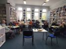 Zdjęcie przedstawia ludzi w bibliotece