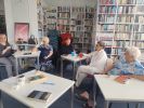 Zdjęcie przedstawia ludzi w bibliotece
