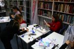 Zdjęcie przedstawia ludzi w bibliotece