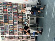 Zdjęcie przedstawia ludzi w bibliotece