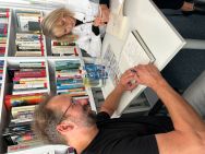 Zdjęcie przedstawia ludzi w bibliotece