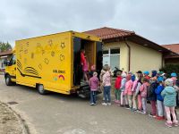 zolty samochod i duzo dzieci