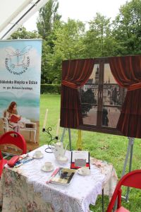 Na zdjęciu dekoracja do Narodowego Czytania, a w niej m.in. baner biblioteki, okno z widokiem na ulice Lwowa z 1910 roku, oraz stolik z ksiazkami i zastawa porcelanowa