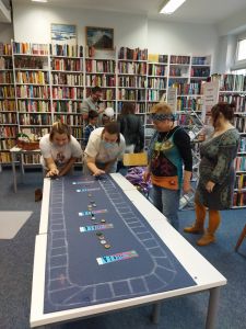 Zdjęcie przedstawia grupę osób grających w kapsle