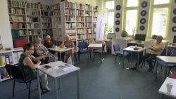Zdjęcie przedstawia ludzi w bibliotece