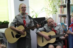 Dwie dziewczynki grają na gitarze i śpiewają w bibliotece