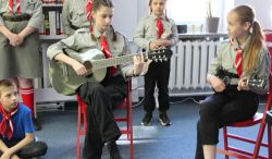 Dwie dziewczynki grają na gitarze i śpiewają w bibliotece