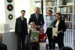 Cztery osoby i dwoje dzieci z nagrodą w bibliotece.