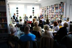 Zdjęcie przedstawia ludzi w bibliotece