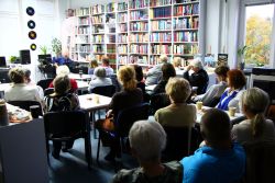Zdjęcie przedstawia ludzi w bibliotece