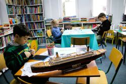 Zdjęcie przedstawia ludzi w bibliotece