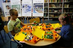 Zdjęcie przedstawia ludzi w bibliotece