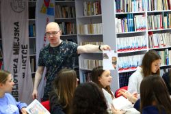 Zdjęcie przedstawia ludzi w bibliotece