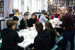 Zdjęcie przedstawia ludzi w bibliotece