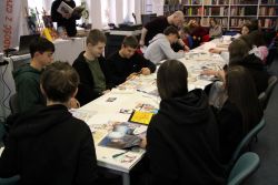 Zdjęcie przedstawia ludzi w bibliotece