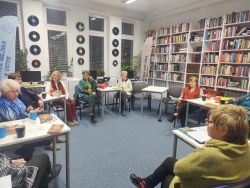 Zdjęcie przedstawia ludzi w bibliotece