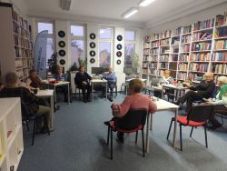 Zdjęcie przedstawia ludzi w bibliotece