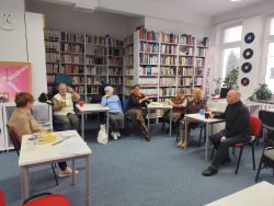 Zdjęcie przedstawia ludzi w bibliotece