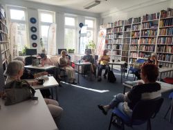 Zdjęcie przedstawia ludzi w bibliotece