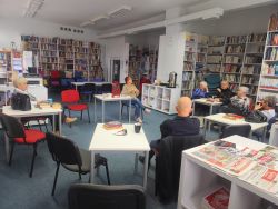 Zdjęcie przedstawia ludzi w bibliotece