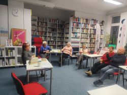 Zdjęcie przedstawia ludzi w bibliotece