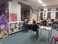 Zdjęcie przedstawia ludzi w bibliotece