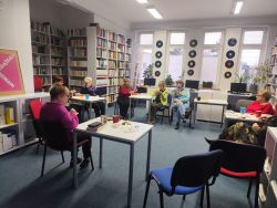 Zdjęcie przedstawia ludzi w bibliotece