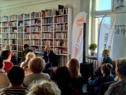 Zdjęcie przedstawia ludzi w bibliotece