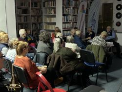 Zdjęcie przedstawia ludzi w bibliotece