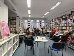 Zdjęcie przedstawia ludzi w bibliotece