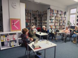 Zdjęcie przedstawia ludzi w bibliotece