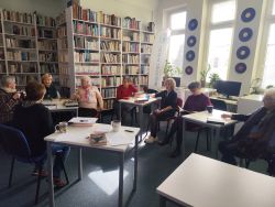 Zdjęcie przedstawia ludzi w bibliotece