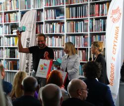 Zdjęcie przedstawia ludzi w bibliotece