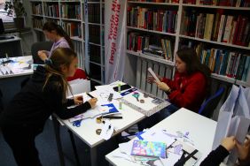 Zdjęcie przedstawia ludzi w bibliotece