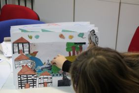 Zdjęcie przedstawia ludzi w bibliotece