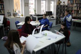 Zdjęcie przedstawia ludzi w bibliotece